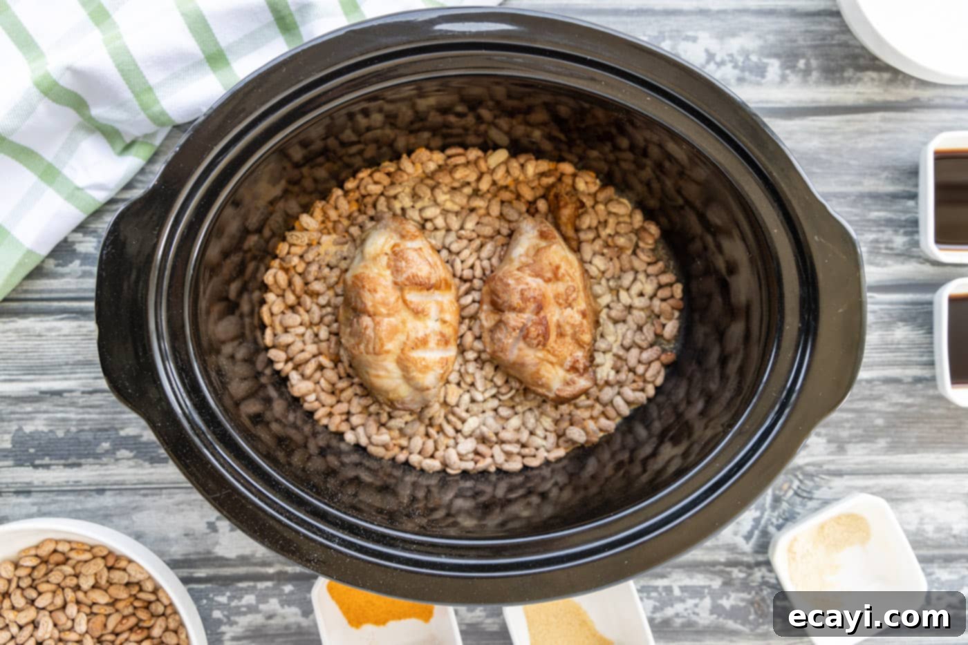 Effortless Slow Cooker Pinto Beans 7 Smoked turkey tails placed on top of seasoned pinto beans in a crockpot