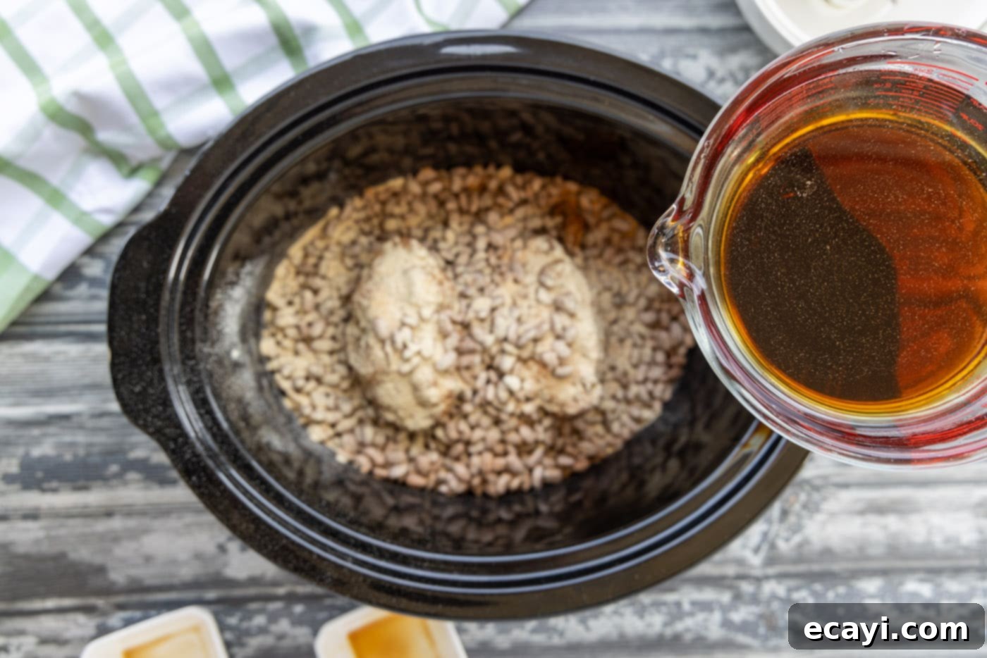 Effortless Slow Cooker Pinto Beans 10 Pouring the mixture of liquid smoke, soy sauce, and water over the pinto beans and turkey tails