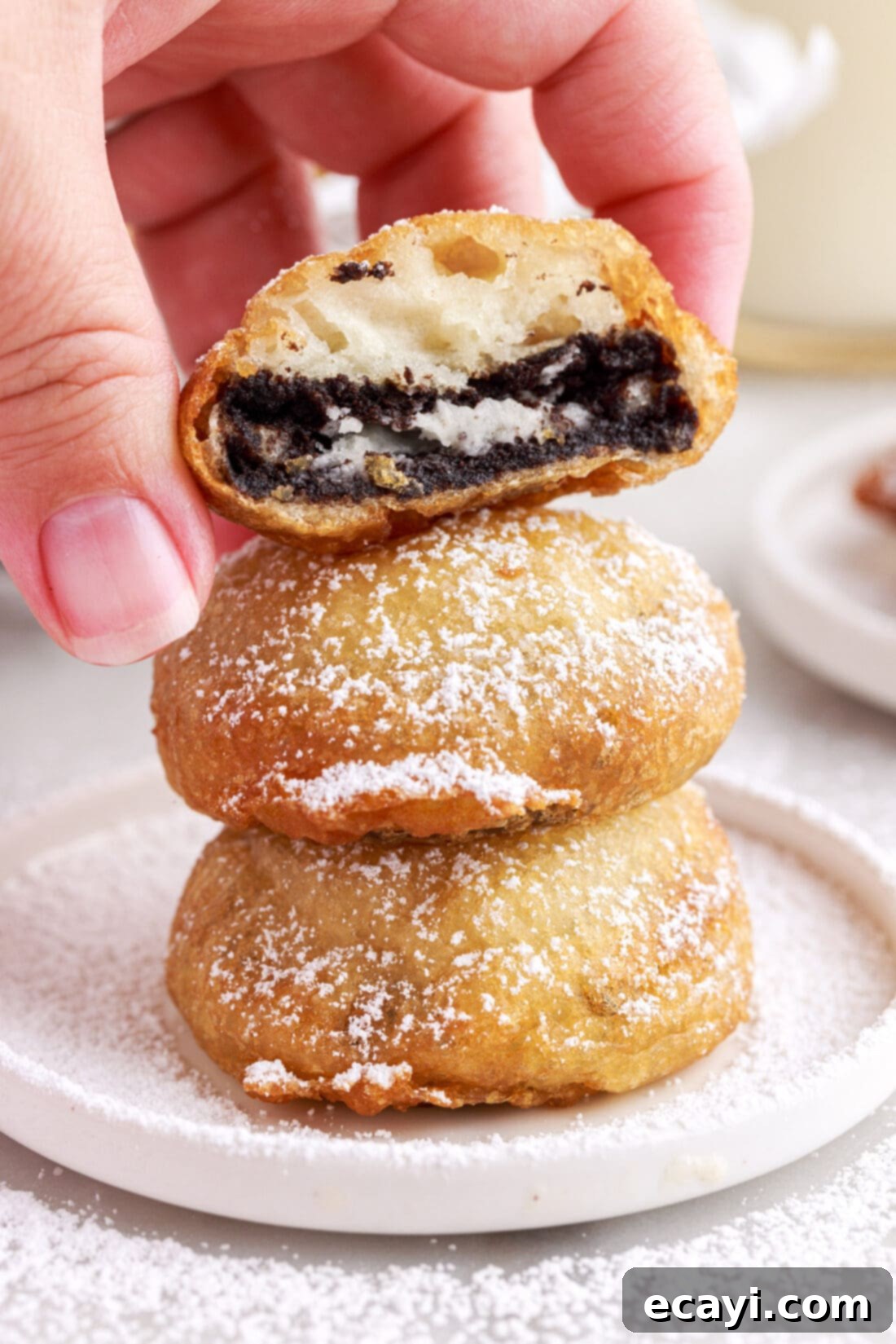 Deep-Fried Oreo Delight 9 A neat stack of three freshly fried Oreos, perfectly golden-brown and glistening with powdered sugar.