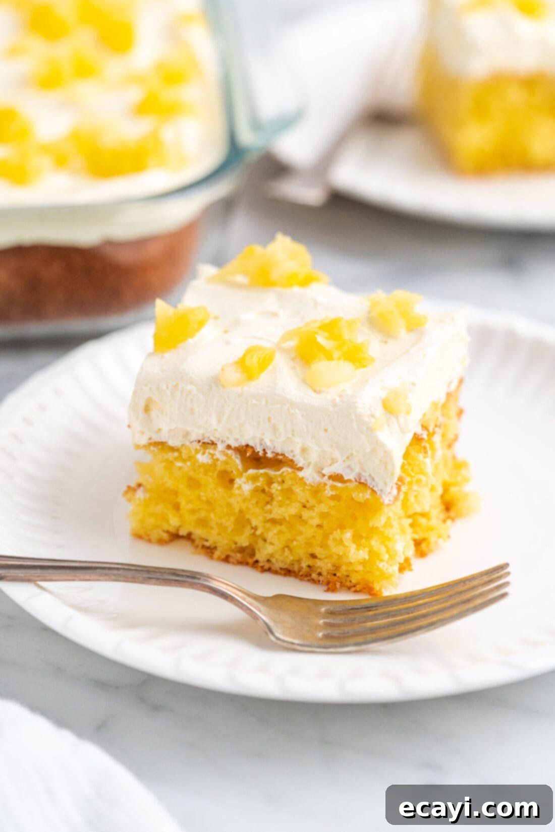 Radiant Pineapple Delight 2 Slice of incredibly moist Pineapple Sunshine Cake with fluffy topping