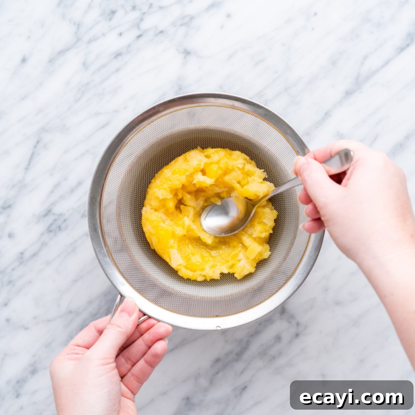 Radiant Pineapple Delight 9 Methodically straining crushed pineapple, separating juice from solids