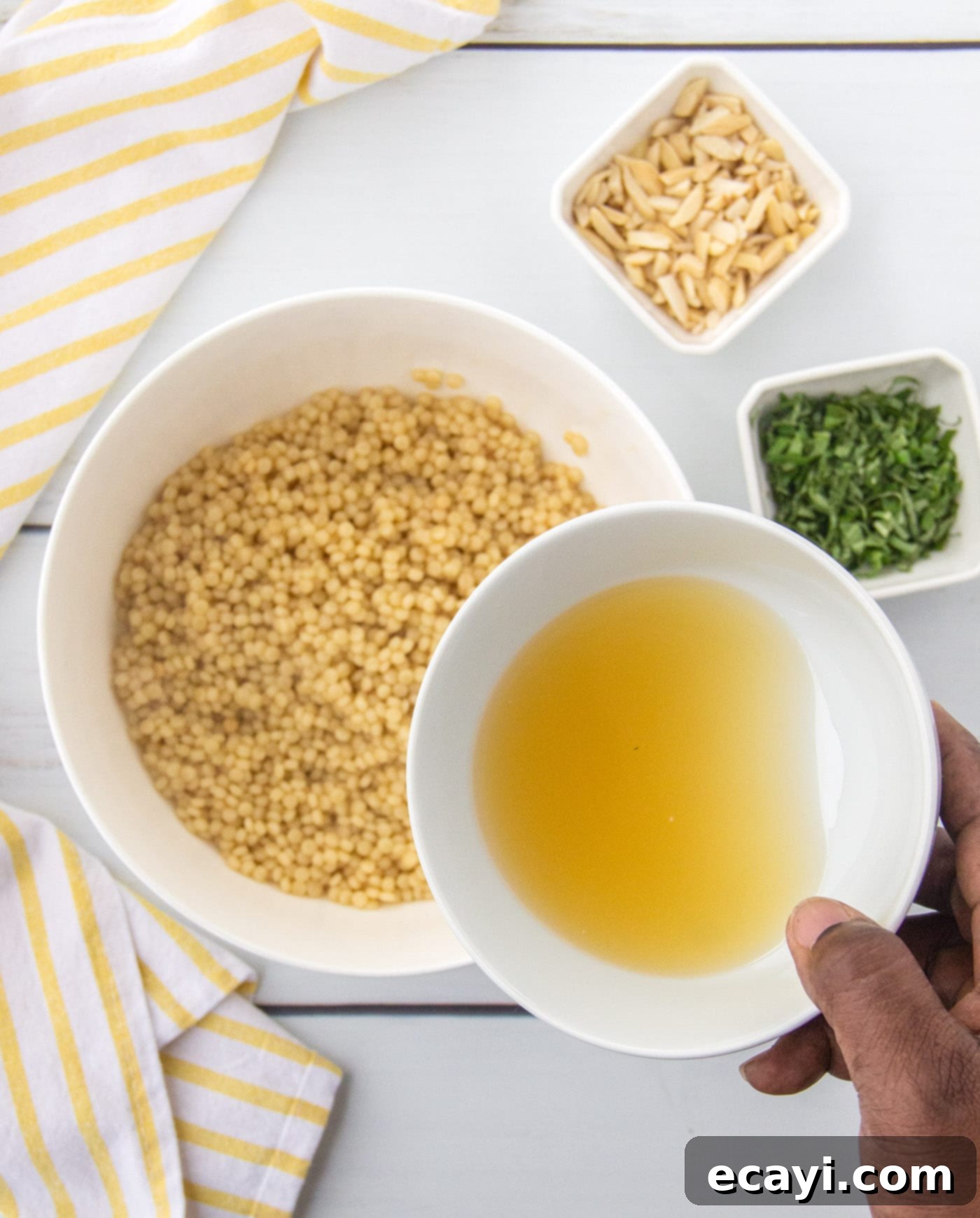 Bright Lemon Couscous 7 Adding lemon juice mixture, fresh basil, and slivered almonds to cooked couscous in a mixing bowl