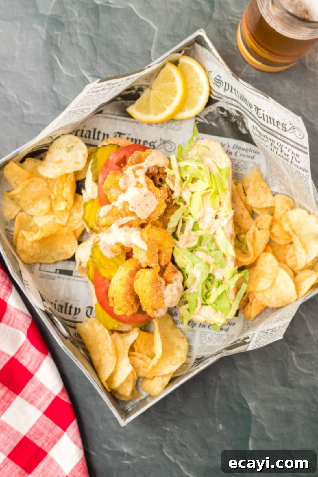 Crispy Golden Shrimp Po' Boy 13 A fully loaded Shrimp Po Boy sandwich in a classic diner basket with a side of potato chips, ready to be enjoyed.
