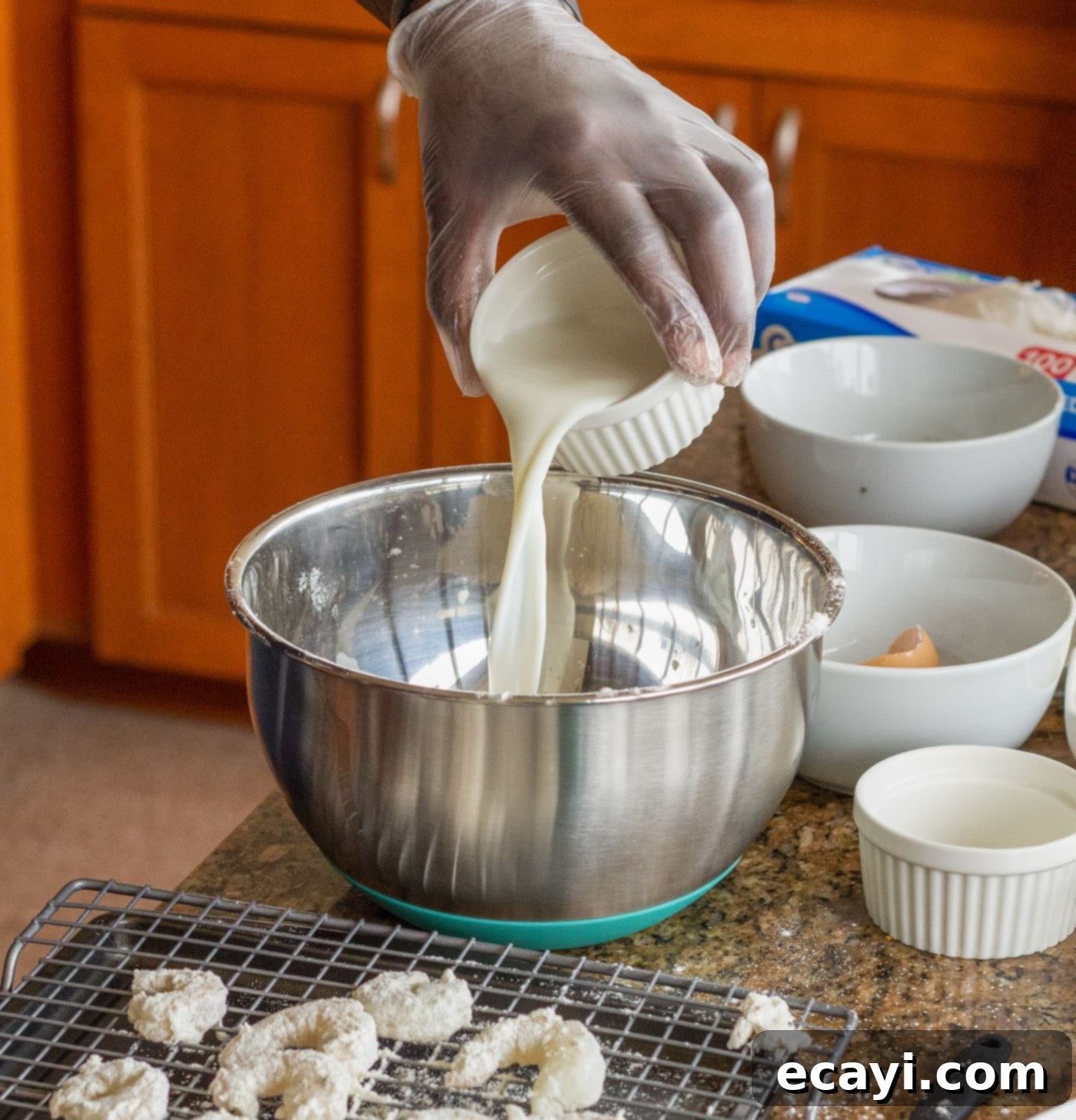 Crispy Golden Shrimp Po' Boy 6 Pouring milk into the egg and flour mixture to create the wet batter for dredging shrimp.