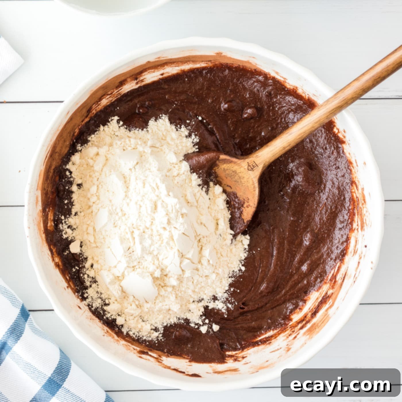 Cookie Brownie Perfection 9 wooden spoon carefully stirring flour into rich brownie batter