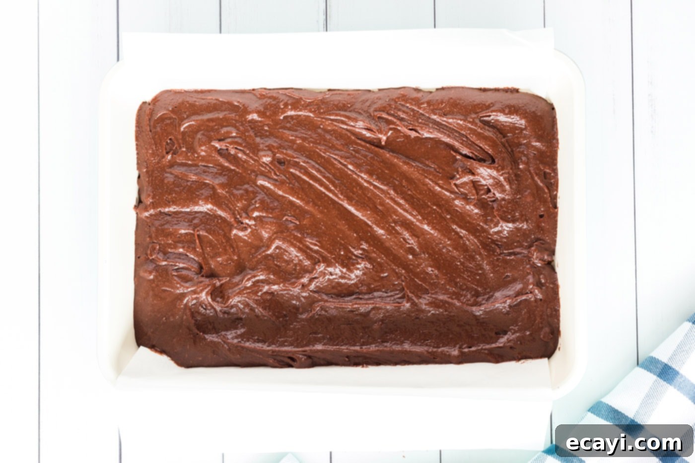 Cookie Brownie Perfection 10 smooth brownie batter spread evenly in a parchment-lined baking dish