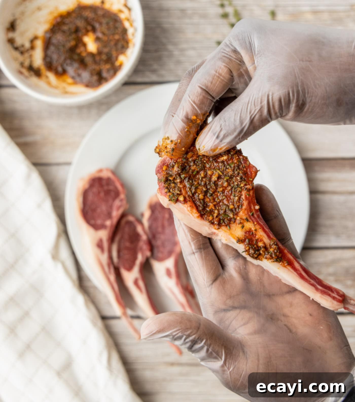Char-Grilled Lamb Delights 6 Hands carefully rubbing spices onto lamb loin chops, ensuring even coverage.