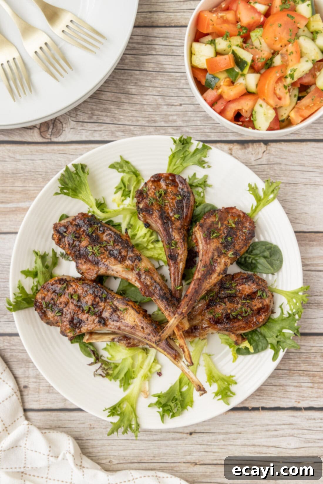 Char-Grilled Lamb Delights 10 An overhead photo of perfectly Grilled Lamb Chops arranged on a plate with fresh greens.
