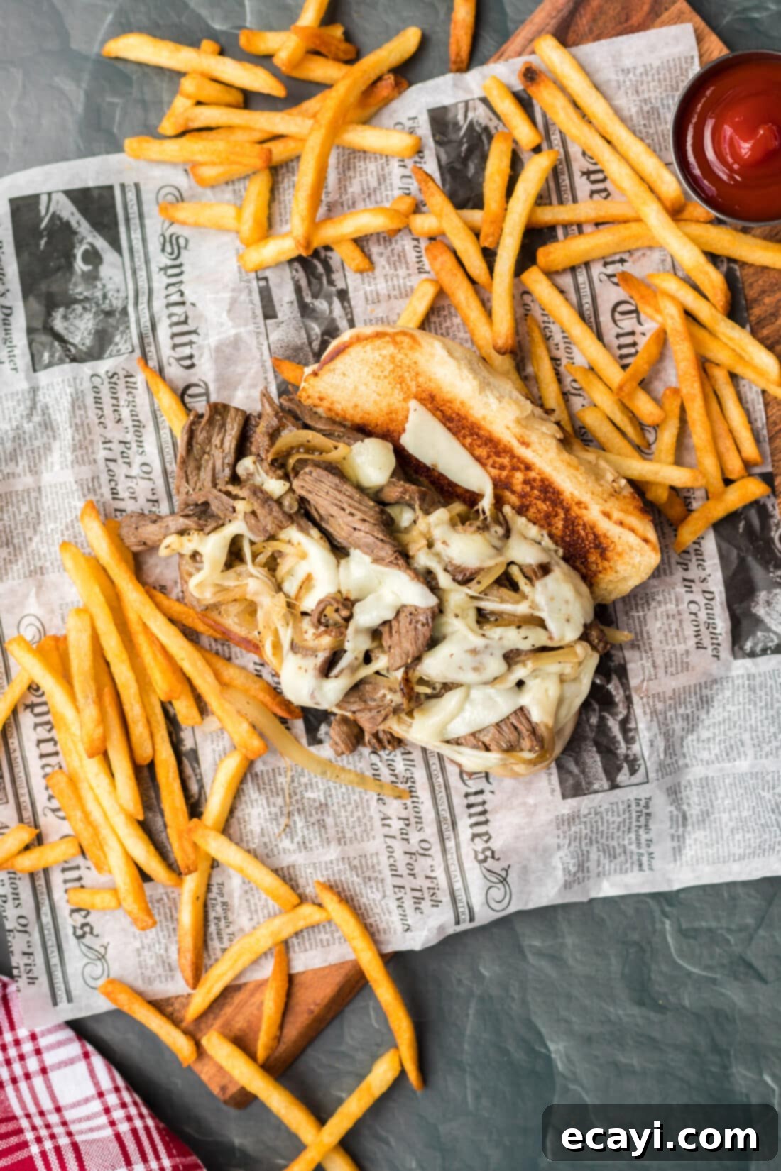 Philly's Legendary Cheesesteak 11 Philly Cheese Steak on parchment with fries