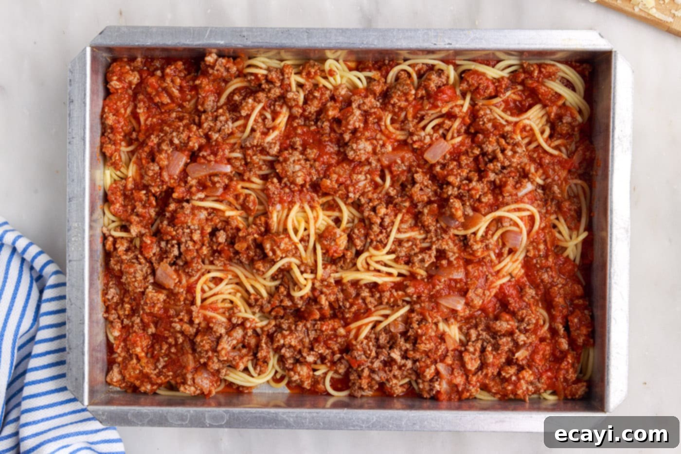 The Ultimate Million Dollar Spaghetti 12 More meat sauce spread on top of the spaghetti layer in the baking dish.