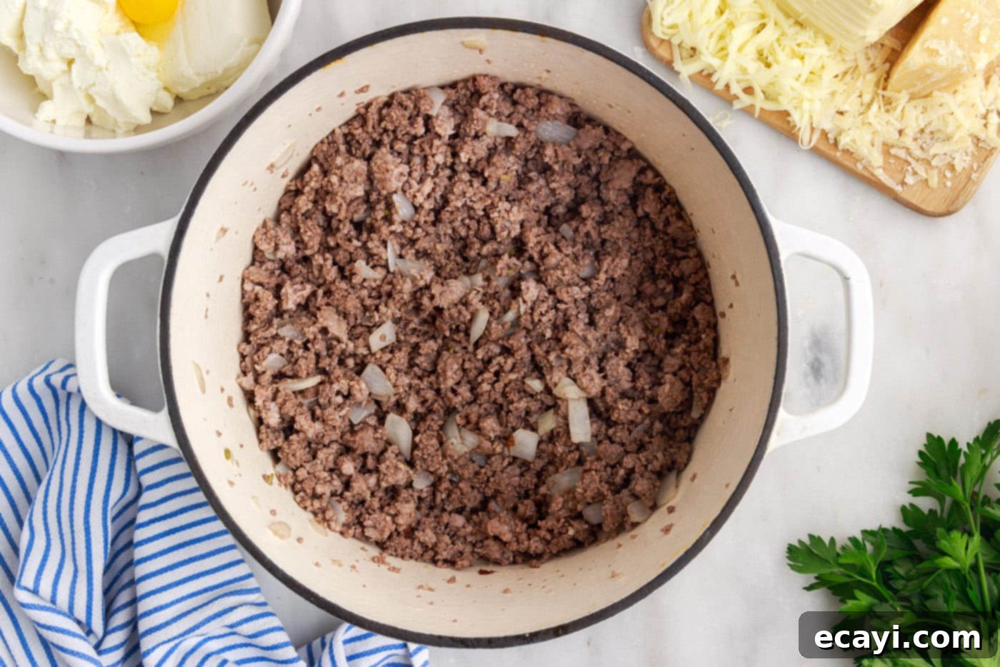 The Ultimate Million Dollar Spaghetti 6 Cooked ground beef and Italian sausage mixture with tender onions in a skillet, ready for marinara.