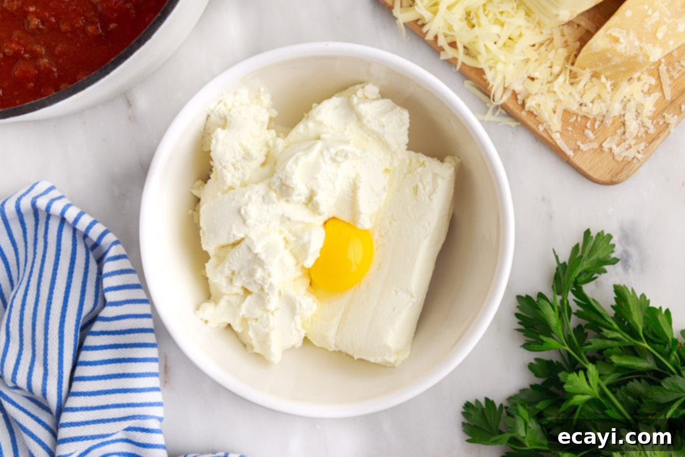 The Ultimate Million Dollar Spaghetti 8 A bowl containing ricotta cheese, softened cream cheese, and a raw egg, ready to be mixed.