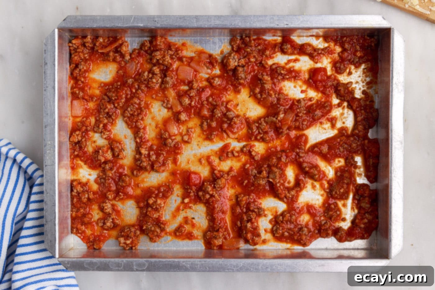 The Ultimate Million Dollar Spaghetti 10 First layer of meat sauce spread evenly at the bottom of a 9x13 inch baking pan.