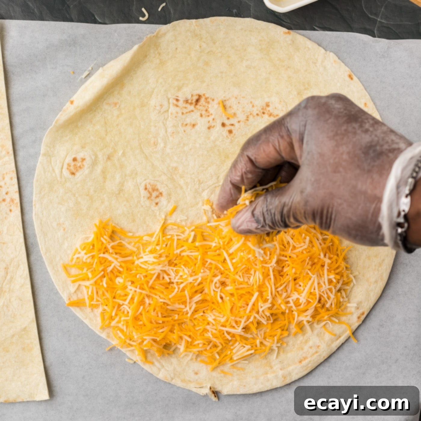 Quesadilla Perfection 6 sprinkling cheese on flour tortilla