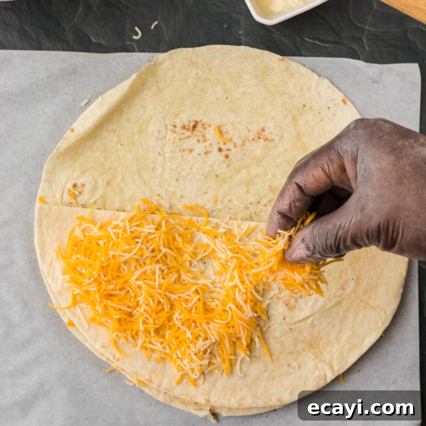 Quesadilla Perfection 8 sprinkling cheese over folded quesadilla