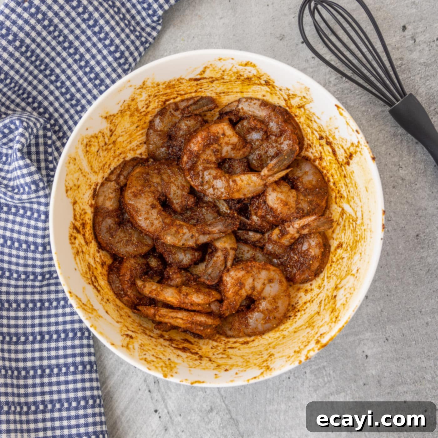 Bayou Blackened Shrimp 6 Raw shrimp coated in blackened seasoning in a mixing bowl