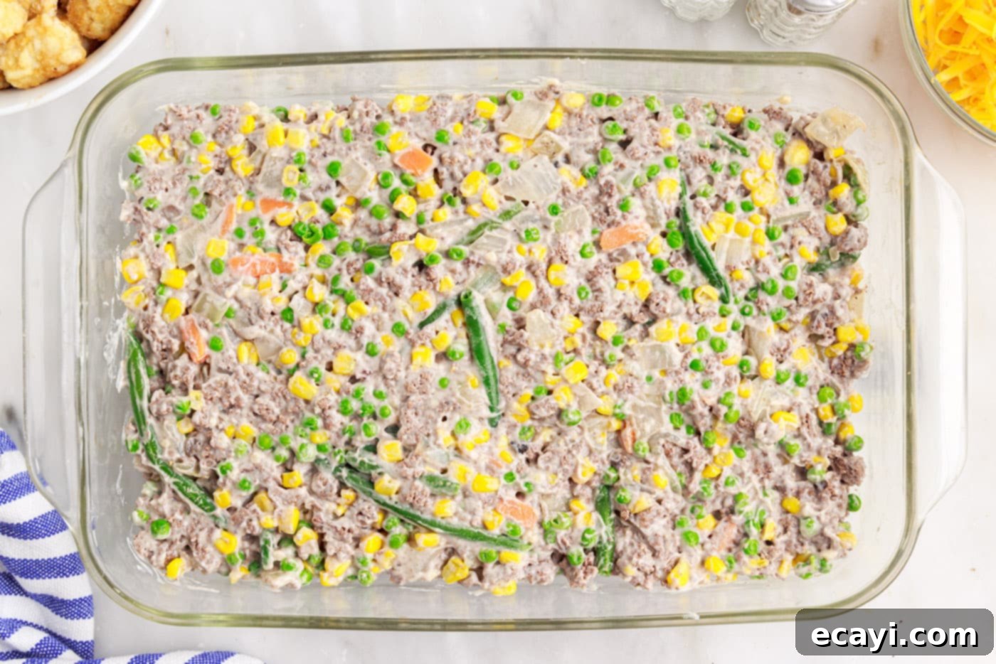 Crispy Tatertot Bake 9 Warm beef and veggie mixture spread evenly in a 9x13 casserole dish