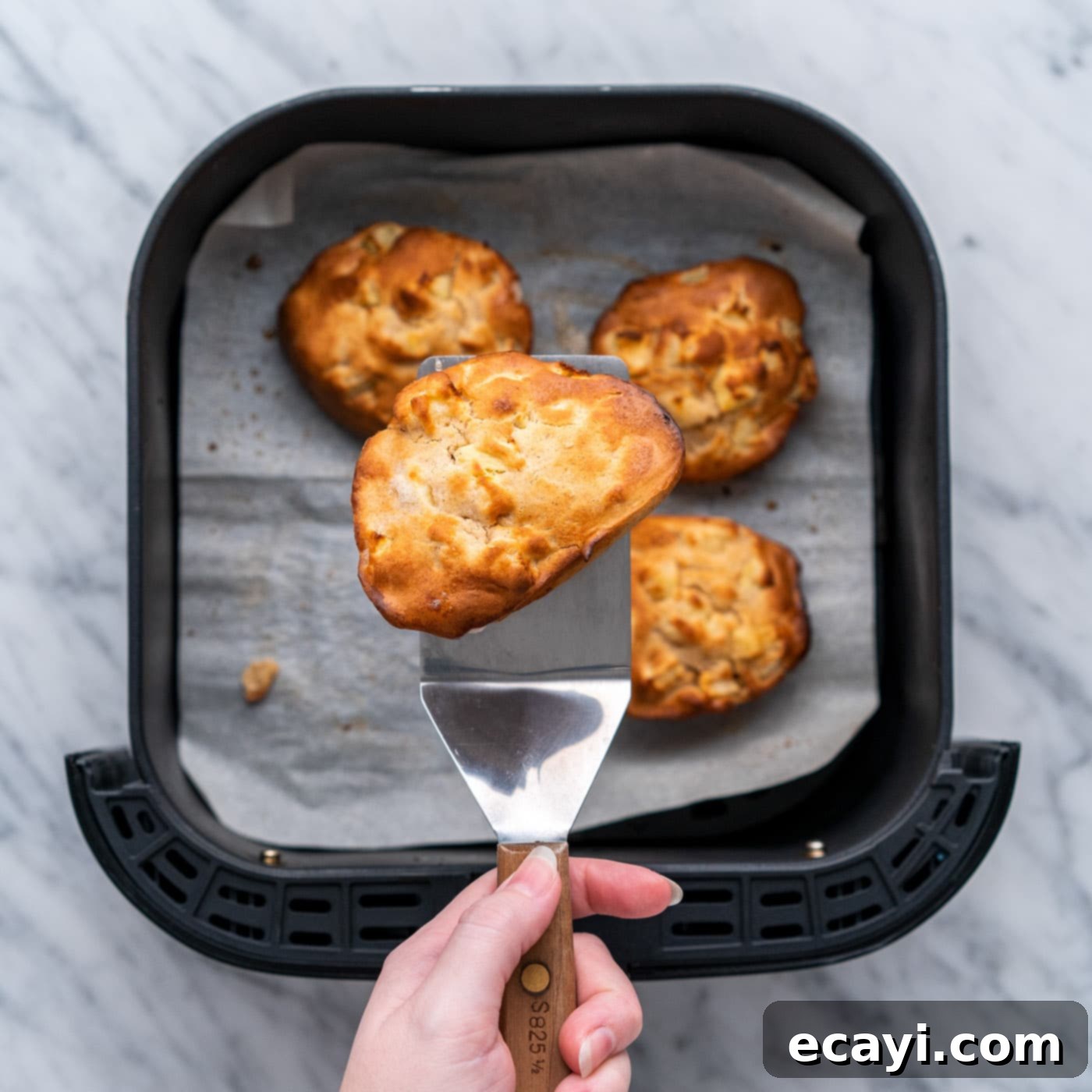 Crispy Air Fryer Apple Fritters 12 golden air fryer apple fritters on a spatula