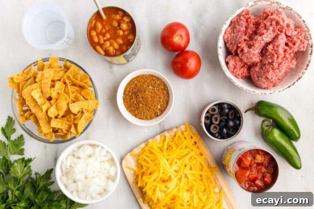 Crunchy Chili Cheese Delight 4 A collection of fresh ingredients laid out, including Frito chips, ground beef, onions, cheese, and canned goods, ready for Frito Pie preparation.