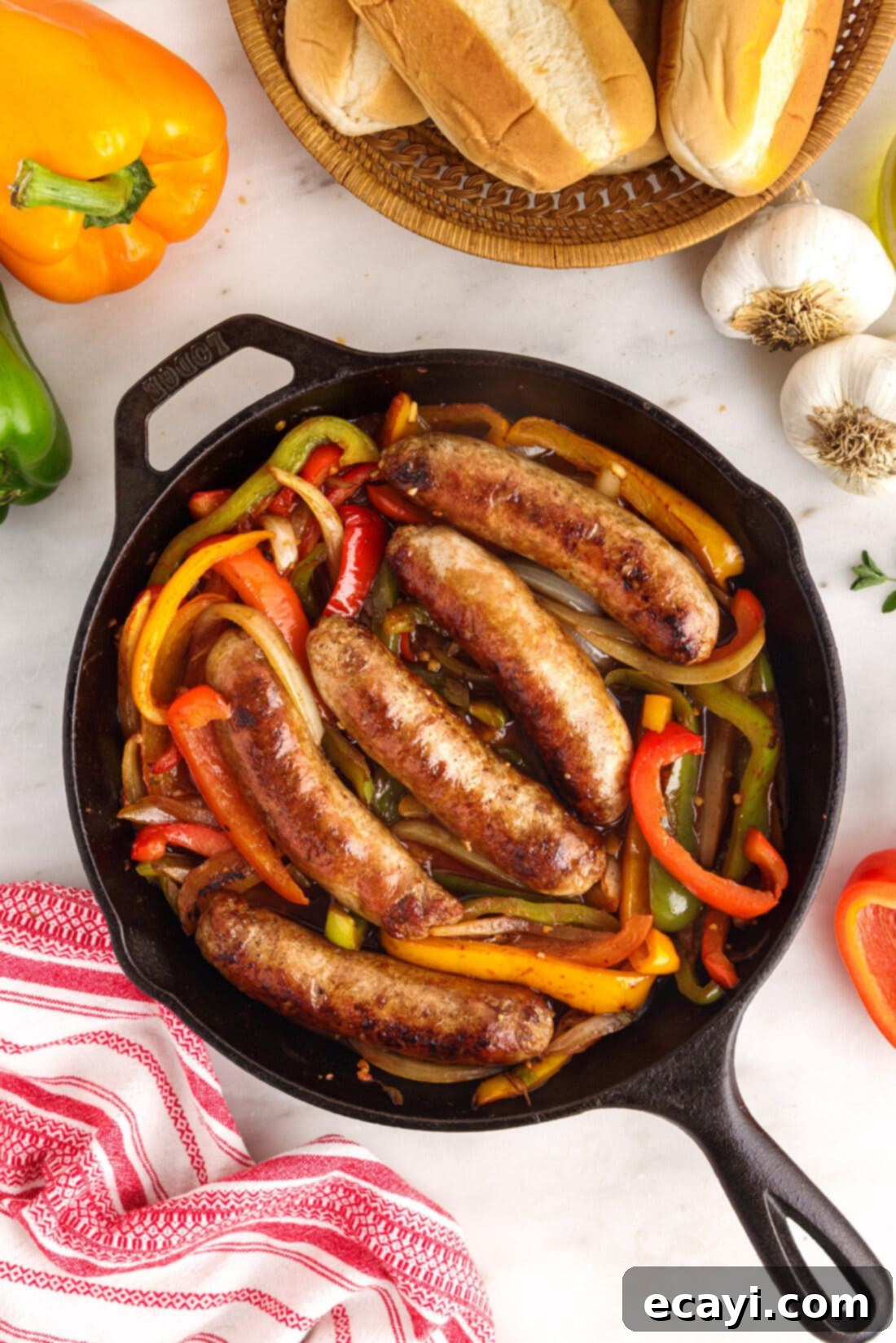 Sausage and Pepper Sizzle 3 Overhead view of a cast iron skillet filled with savory sausage and peppers, garnished with fresh herbs.