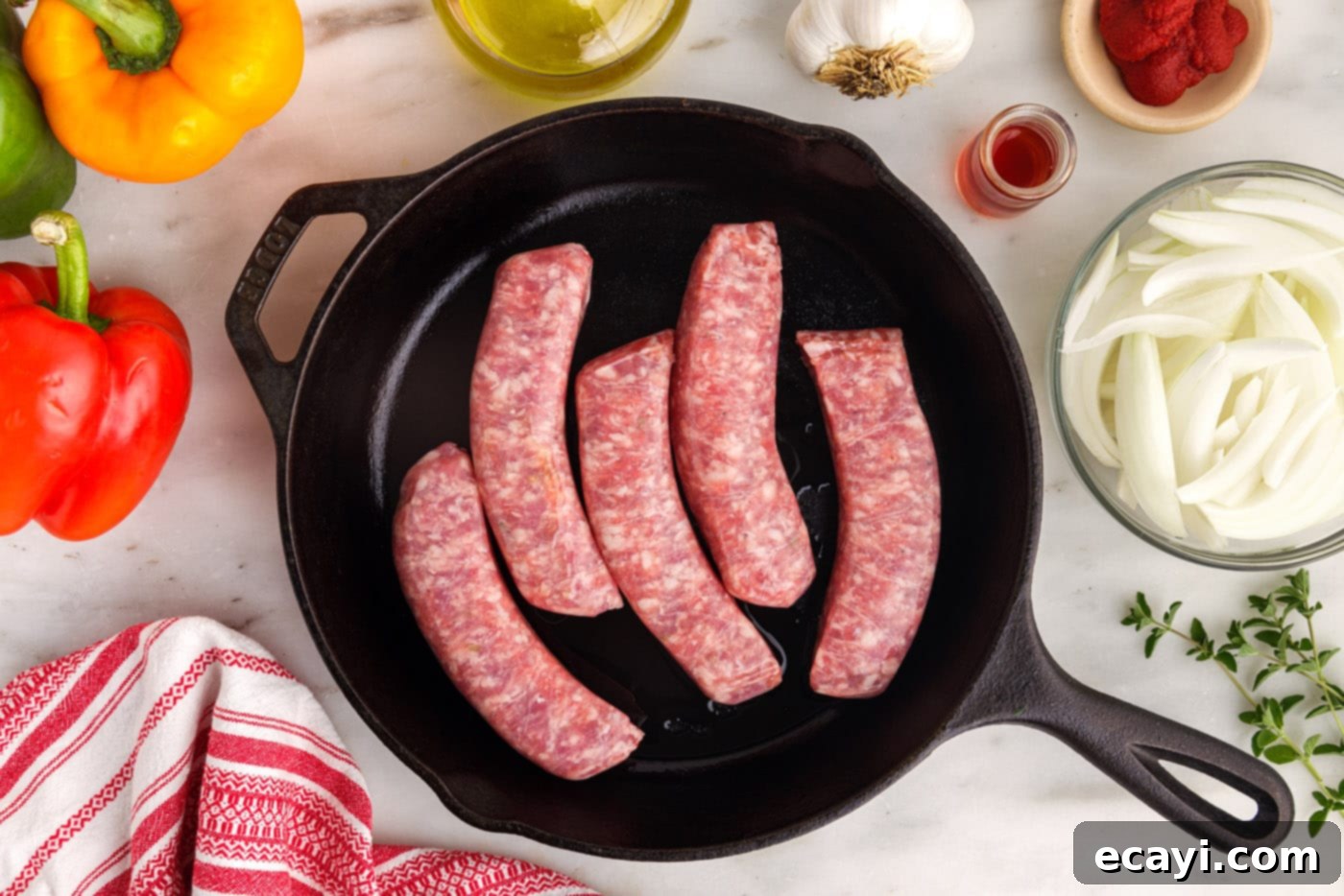 Sausage and Pepper Sizzle 5 Italian sausage links browning in a hot cast iron skillet, showing the initial sear.