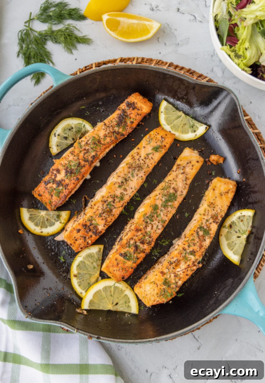 Golden Pan-Seared Salmon 3 Pan Seared Salmon in a skillet with lemons for garnish
