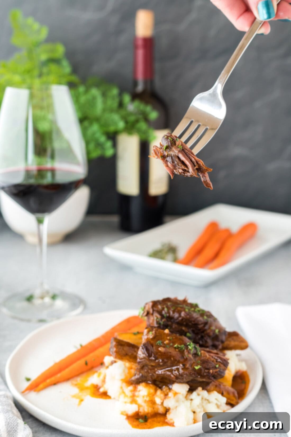 Fall-Off-The-Bone Instant Pot Beef Short Ribs 3 A fork lifting a piece of tender Instant Pot Beef Short Ribs
