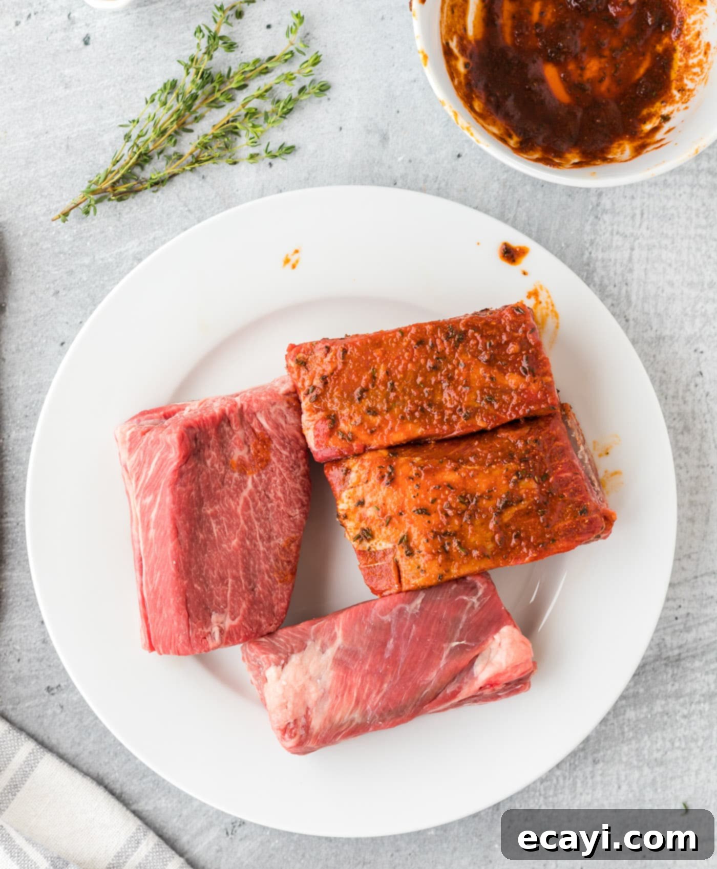 Fall-Off-The-Bone Instant Pot Beef Short Ribs 6 Hands rubbing seasoning mixture into beef short ribs