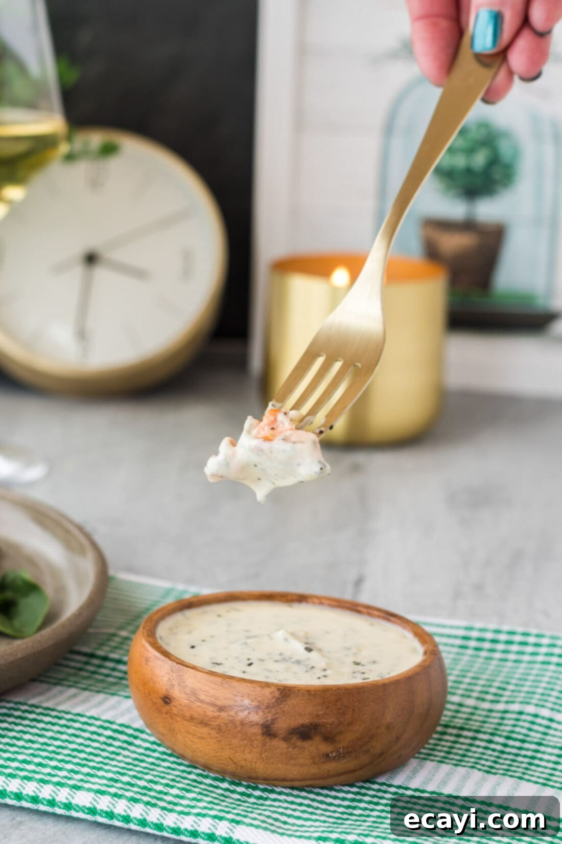 Aromatic Rosemary Cream Sauce 6 Piece of salmon dipped into a bowl of Rosemary Cream Sauce, highlighting its creamy texture.