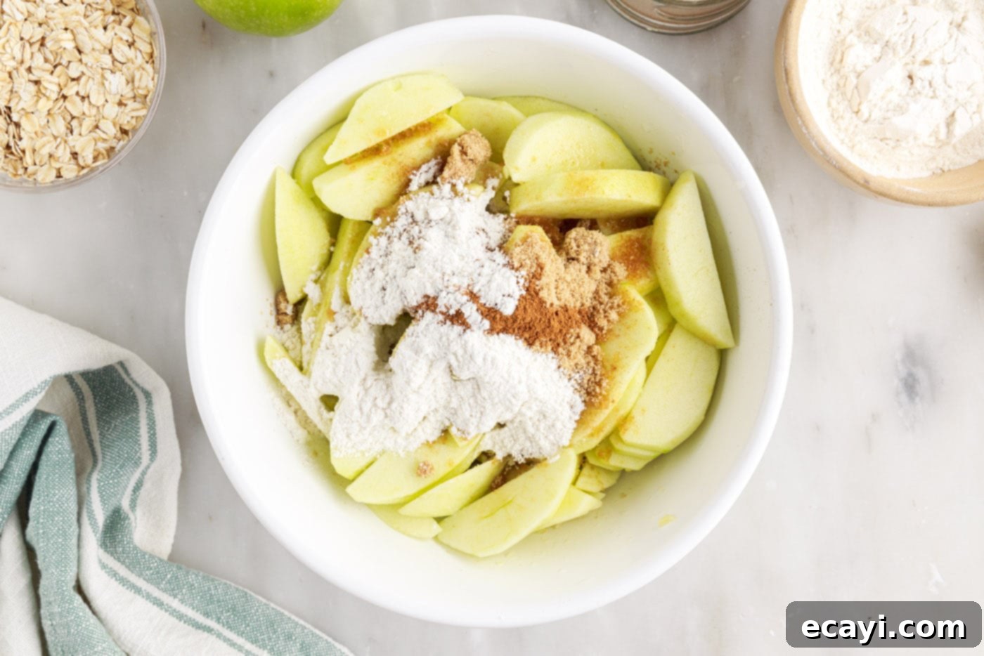 Warm Apple Crumble Delight 5 Sliced apples mixed with brown sugar, cinnamon, and flour in a large mixing bowl, ready for baking.
