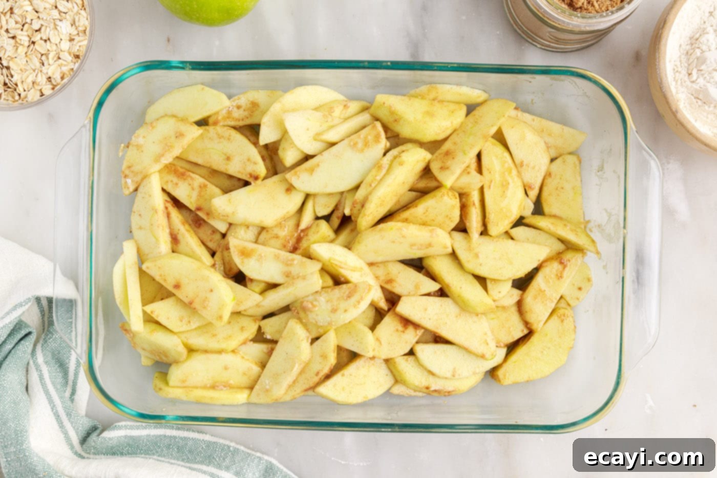 Warm Apple Crumble Delight 7 The spiced apple filling spread evenly in a 9x13 inch baking dish, ready for the crumble topping.