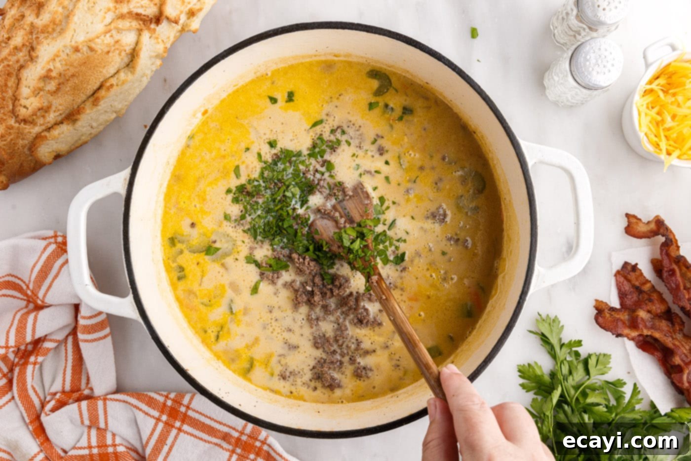 Hearty Cheeseburger Chowder 13 A large pot of cheeseburger soup being stirred with a wooden spoon, showing its rich and creamy texture, ready to be served.