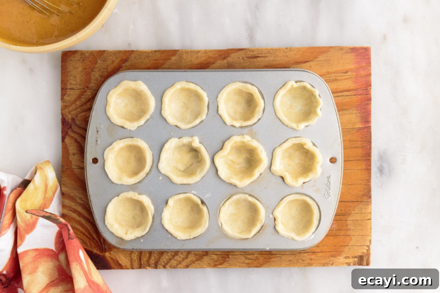 Pumpkin Pie Bites 12 mini pie dough pressed into a muffin tin cavity