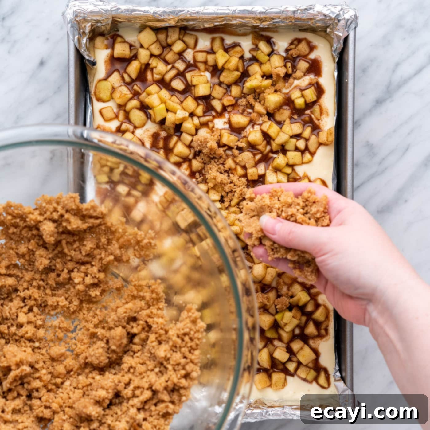 Harvest Caramel Apple Cheesecake Squares 18 Sprinkling streusel topping on top of the apple layer for caramel apple cheesecake bars