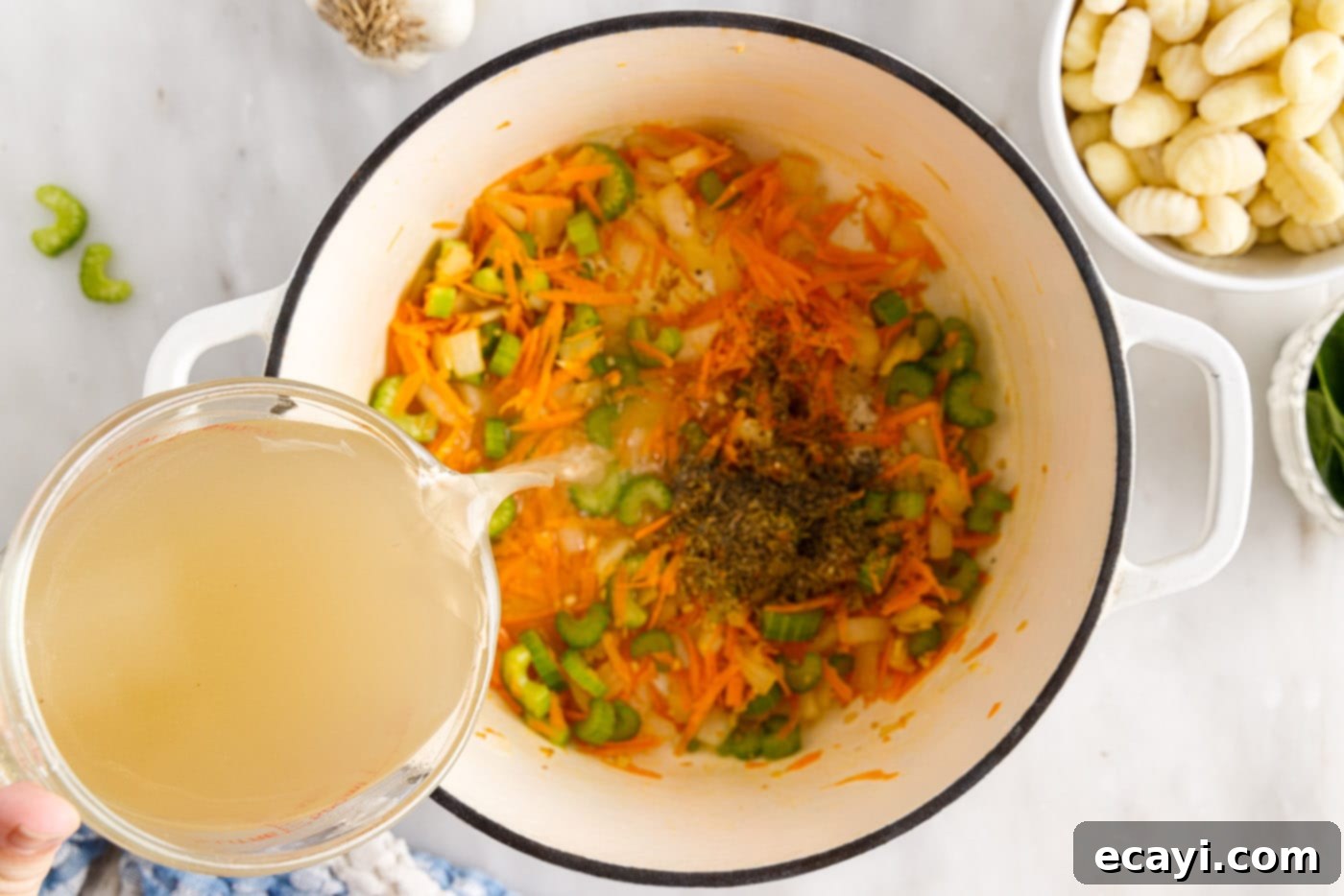 Creamy Gnocchi Chicken Bliss 8 pouring broth over vegetables in a pot