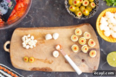 Eye-Popping Halloween Dip 14 using a 1/4 teaspoon to scoop a hole in a mozzarella ball