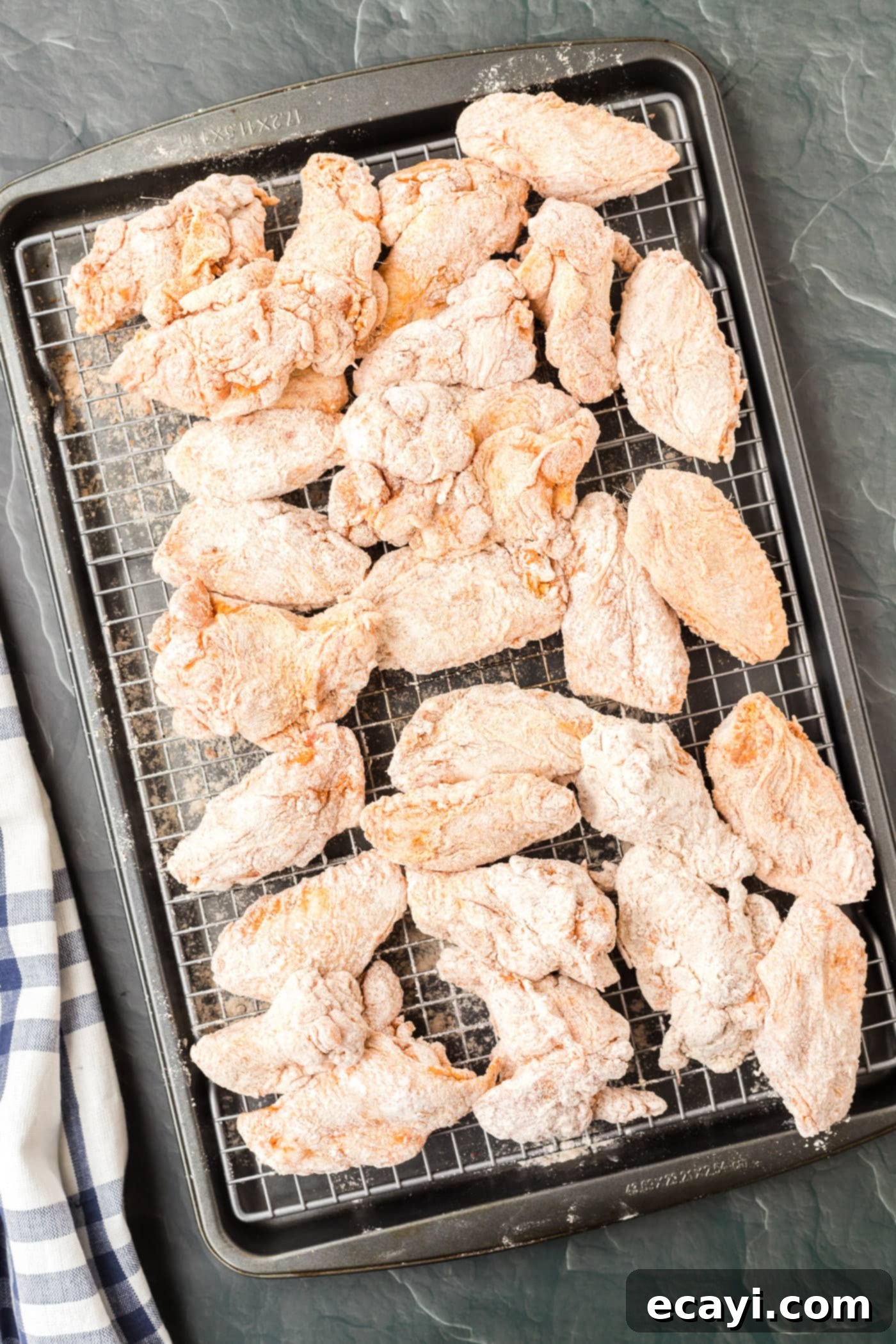 Addictive Korean Crunch 7 flour dredged chicken wings on a baking sheet
