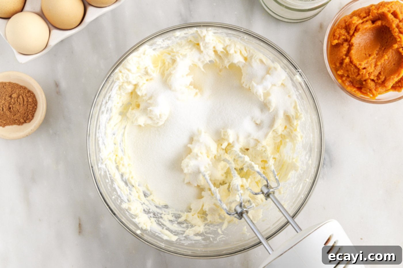 Spiced Mini Pumpkin Cheesecakes 8 beating cream cheese with sugar in a bowl