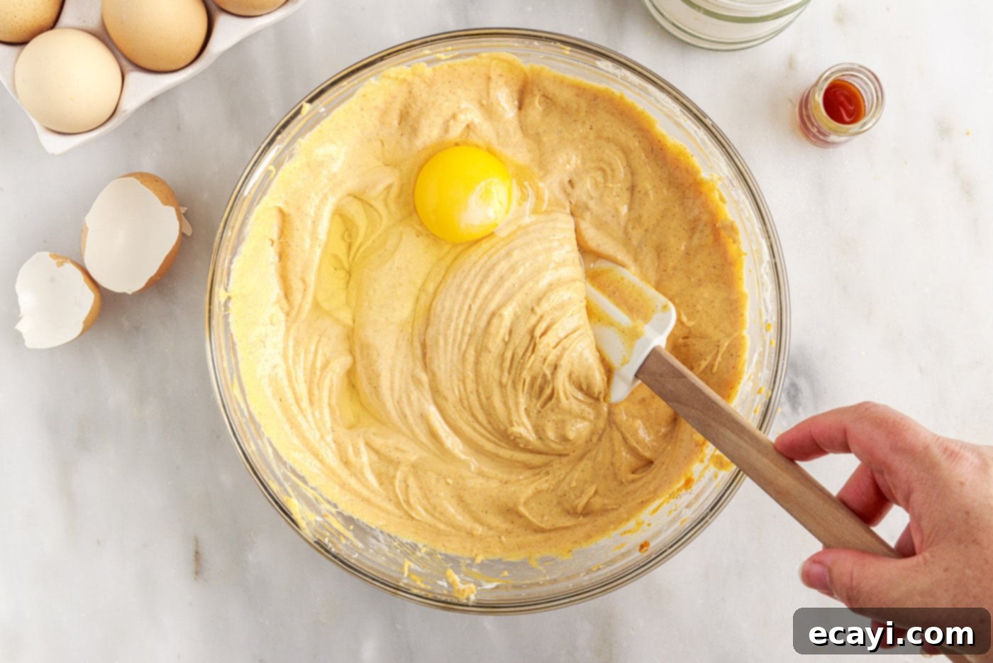 Spiced Mini Pumpkin Cheesecakes 10 mixing eggs into pumpkin cheesecake filling