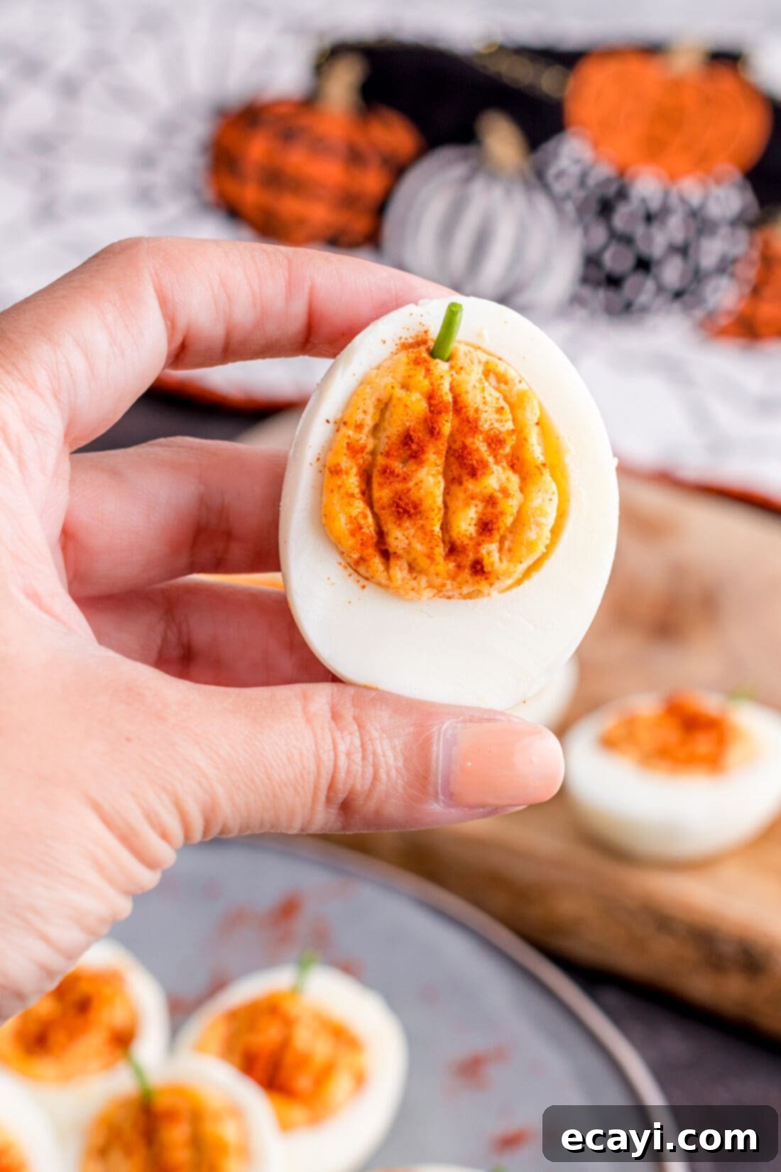 Creamy Pumpkin Deviled Delights 10 A hand holding a beautifully decorated Pumpkin Deviled Egg