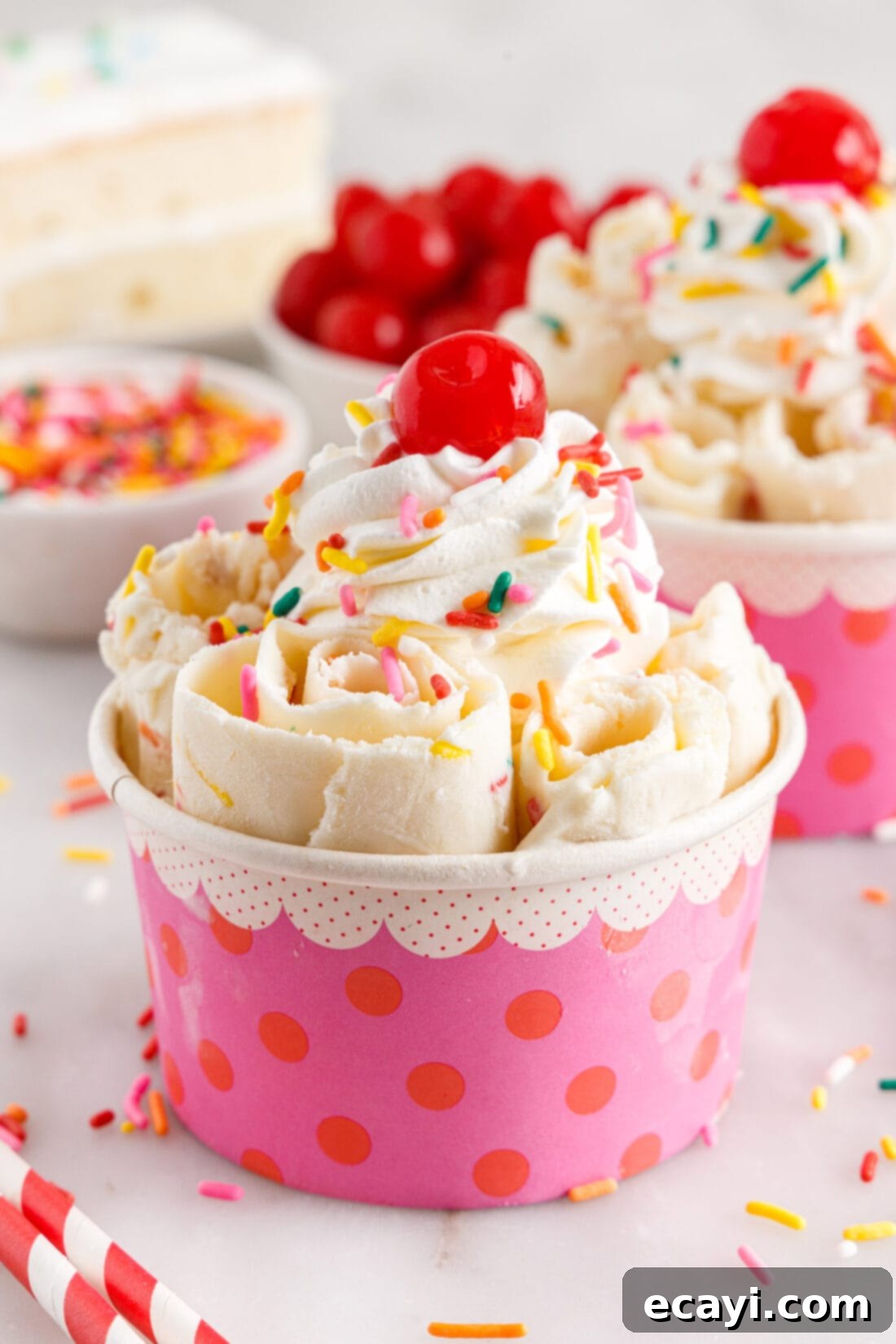 Confetti Cake Swirls 2 A dish of colorful Birthday Cake Rolled Ice Cream adorned with extra sprinkles and a cherry on top.
