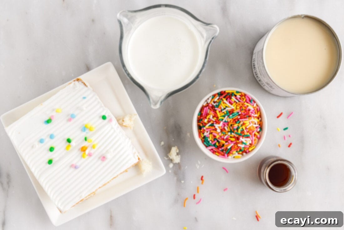 Confetti Cake Swirls 4 All ingredients laid out for making Birthday Cake Rolled Ice Cream, including heavy cream, condensed milk, sprinkles, and cake.