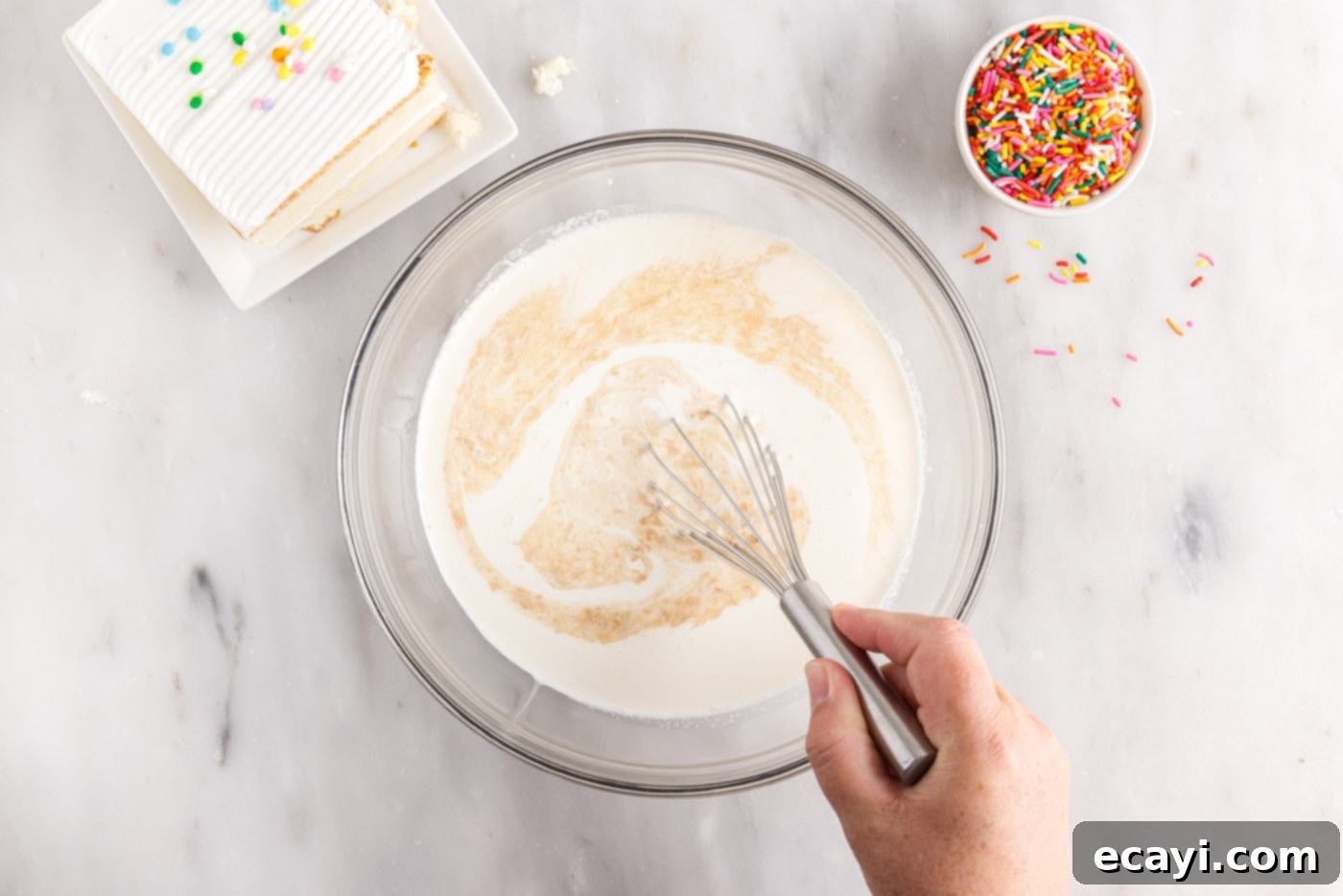 Confetti Cake Swirls 5 Whisking together heavy cream, sweetened condensed milk, salt, and vanilla in a bowl until fully combined.