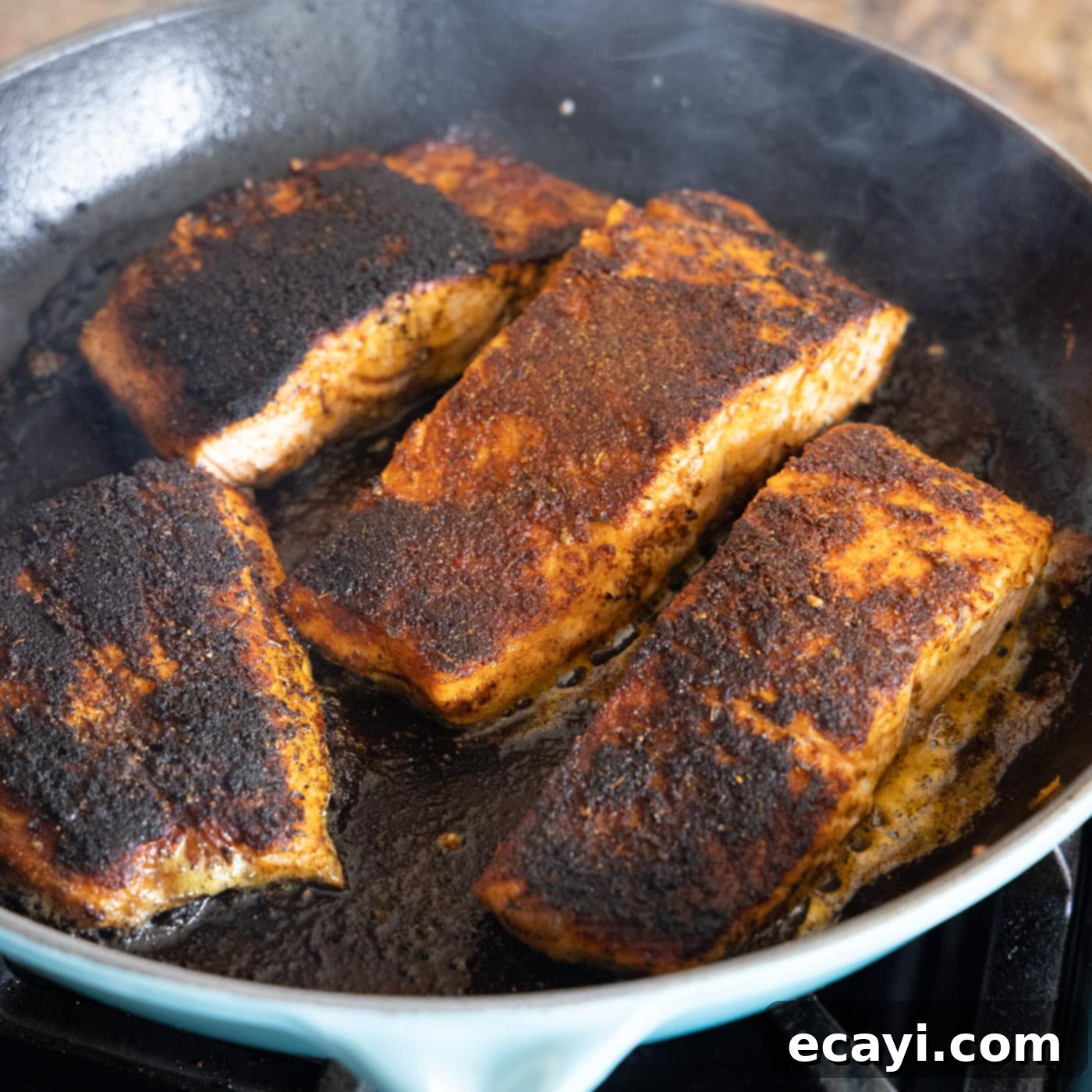 Cajun Seared Salmon 11 Two pieces of perfectly pan-seared blackened salmon, showcasing the beautiful dark crust and inviting texture.