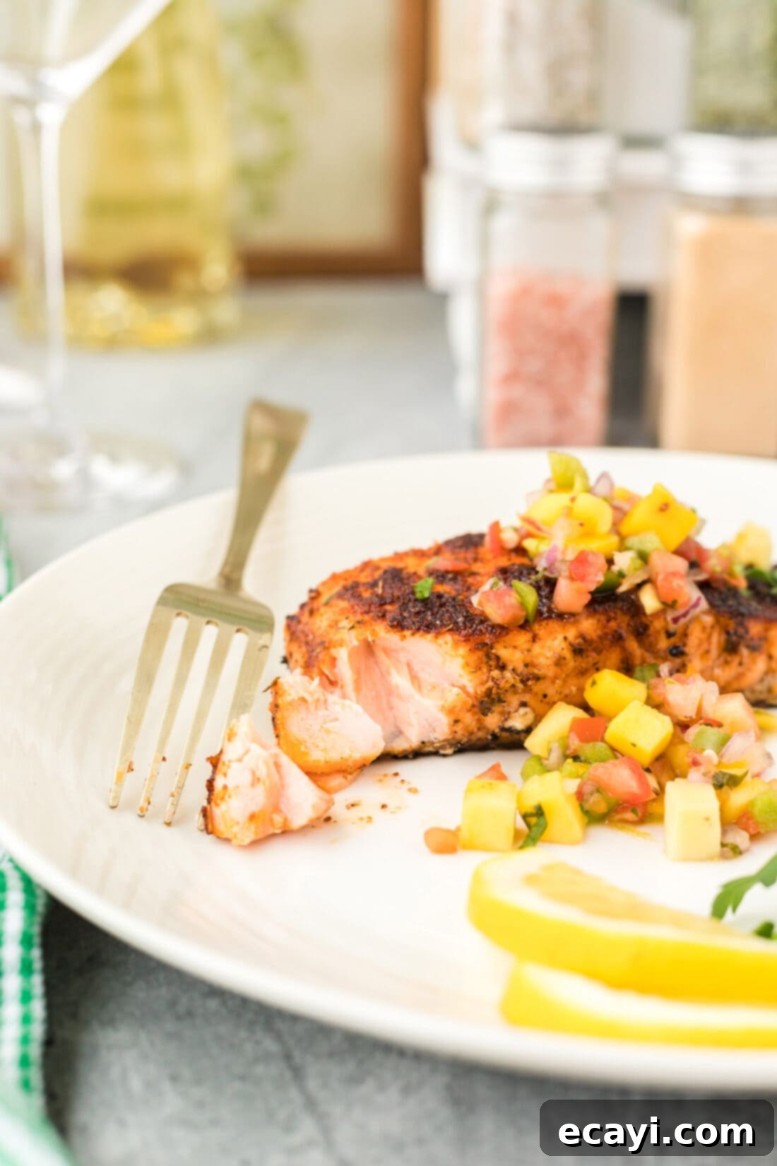 Cajun Seared Salmon 3 A fork piercing into a perfectly cooked, flaky Blackened Salmon filet, showcasing its tender interior and dark, spiced crust.