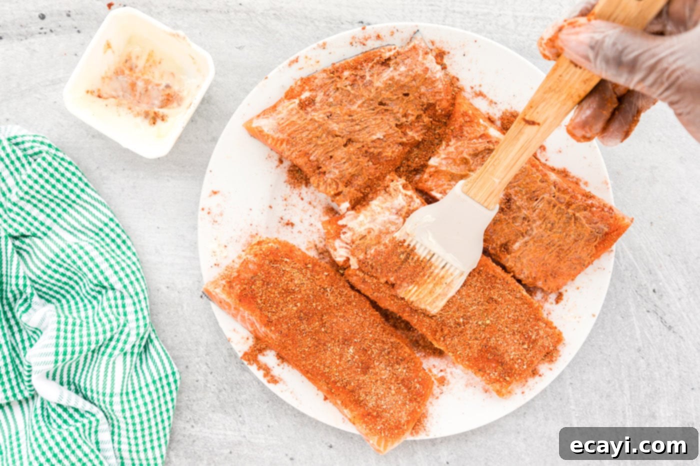 Cajun Seared Salmon 7 A pastry brush dabbing more butter over the blackened seasoning on salmon fillets, enhancing flavor and crust.
