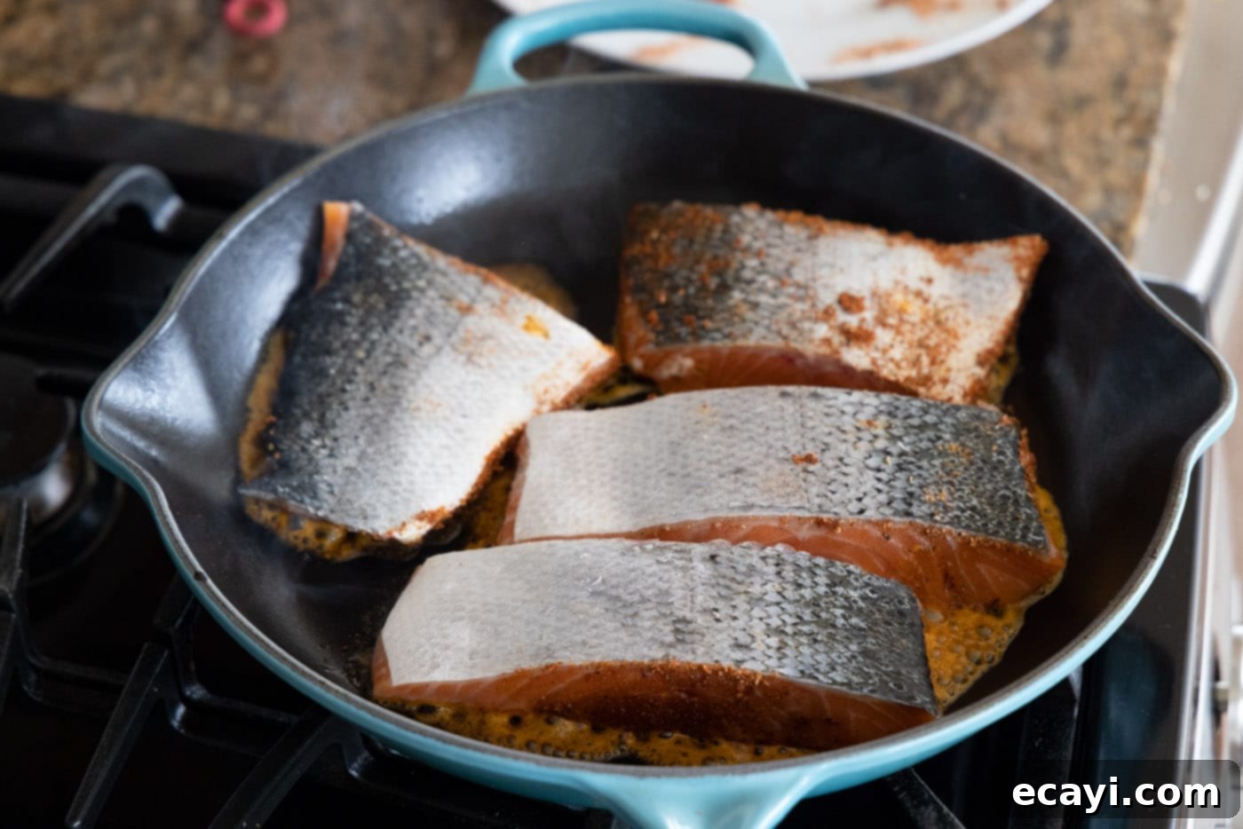 Cajun Seared Salmon 8 Salmon fillets cooking skin side up in a very hot skillet, beginning to develop the blackened crust.