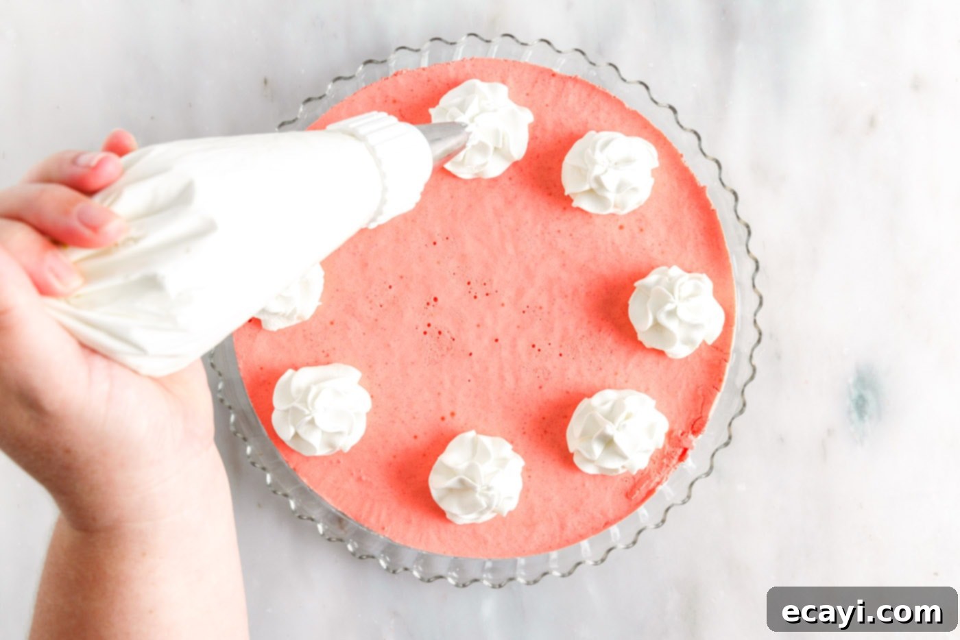 Jell-O Stacked Delight 16 piping whipped cream on top of layered jello pie