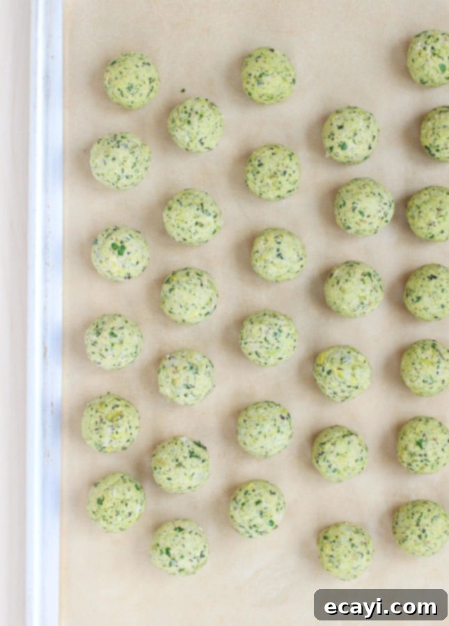 Light & Nutty Baked Pistachio Falafels 3 Raw Oven-Baked Pistachio Falafel mixture rolled into small, uniform balls on a parchment-lined baking sheet, ready for baking.