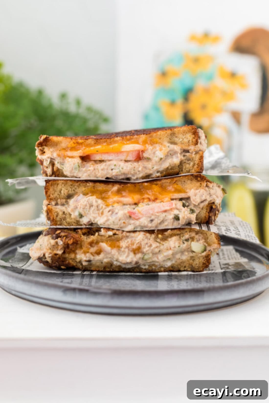 Golden Tuna Grille 2 A stack of three golden brown tuna melts, showcasing the melted cheese and hearty filling.